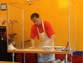 Chef Kneading Dough Behind Glass Partition